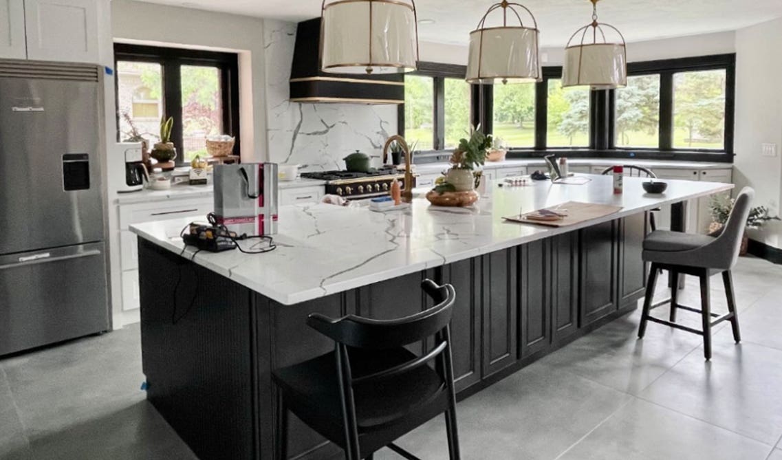 Large gray island with granite counter top similar to slab backplane 