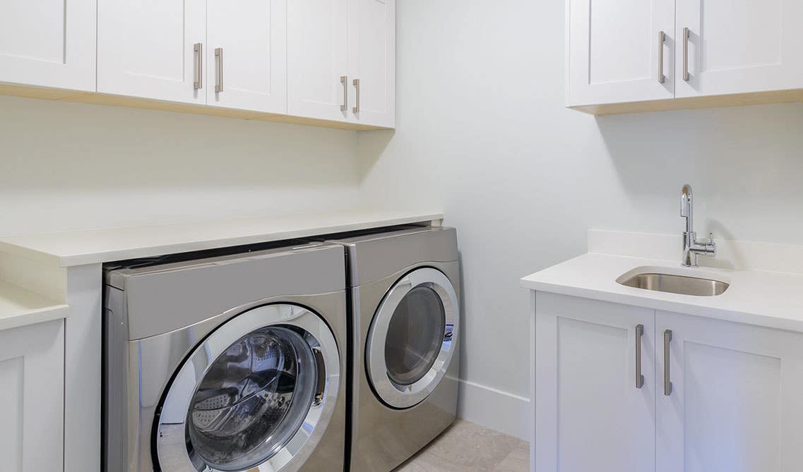 Laundry room with white cabinets