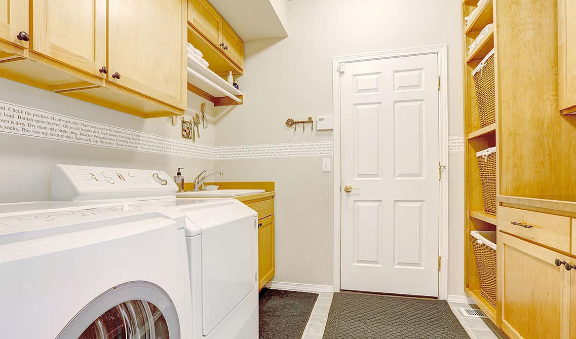 Laundry Room with wood cabinets and washer and dryer, open shelving