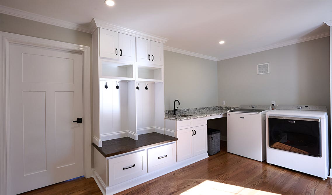 Laundry room with functional storage and seating area 