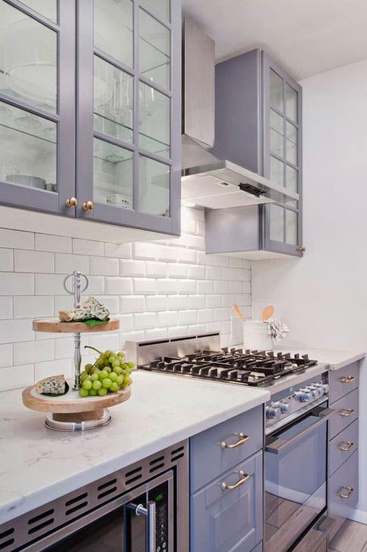 Kitchen design with light purple cabinets and white countertop, subway tile backsplash 