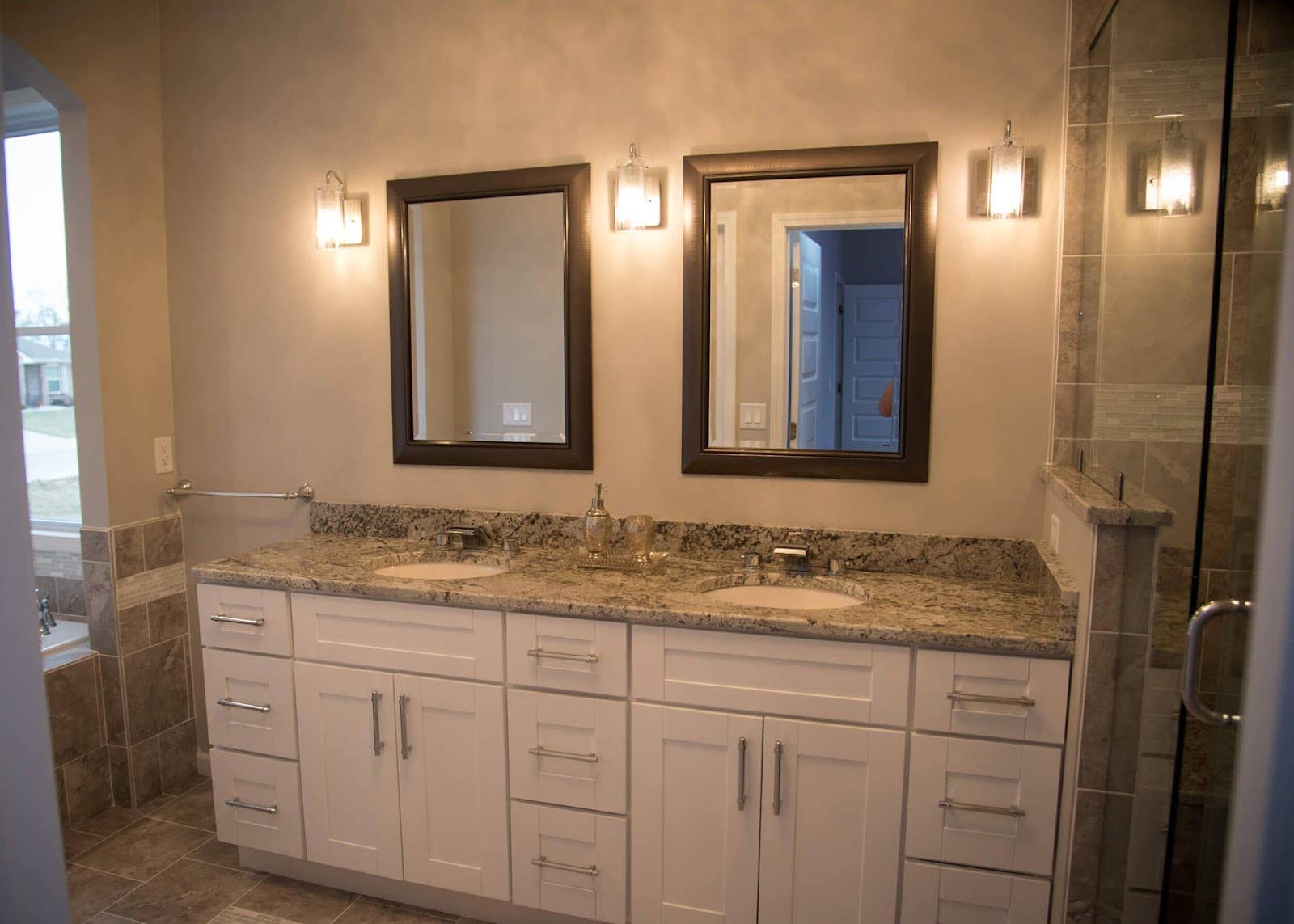 Bathroom features with white vanity and silver hardware, wall lamp lights