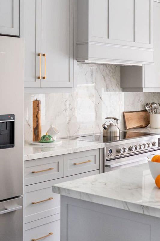 Modern kitchen with Marble Slab backsplash and white cabinets