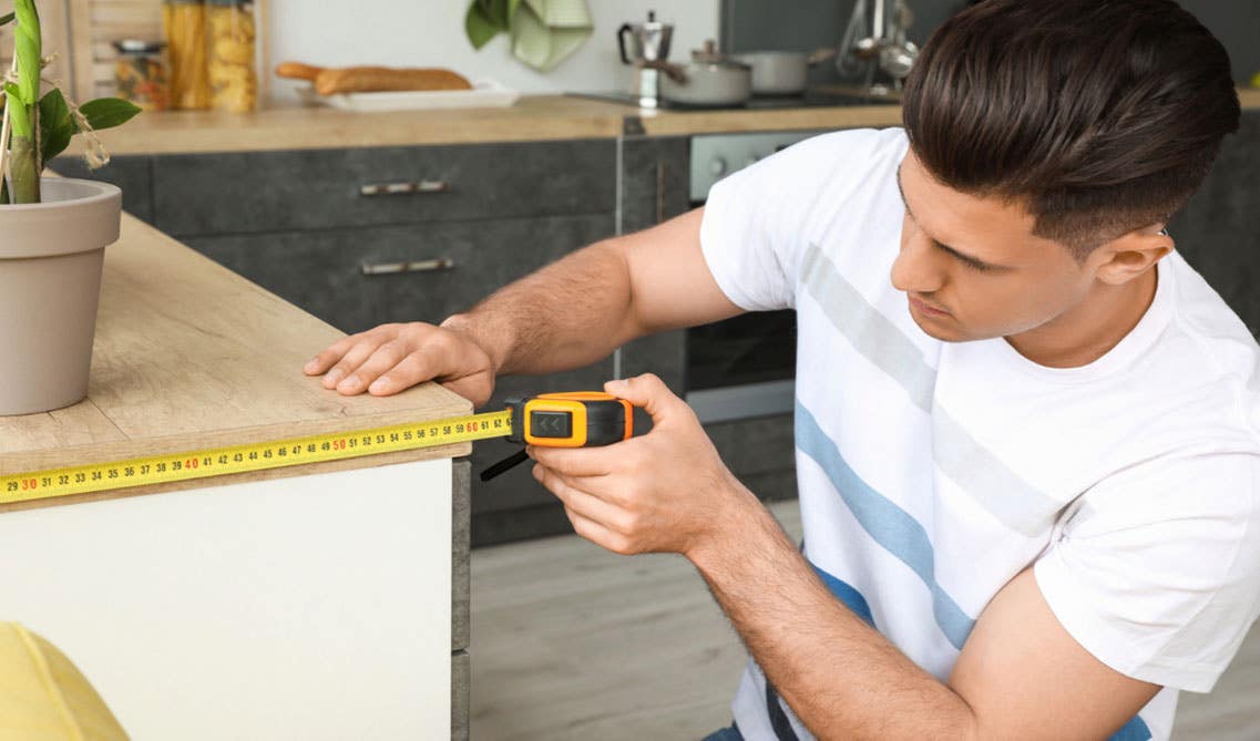 A man Measuring kitchen base cabinets