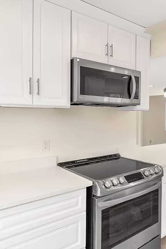 White cabinets paired with microwave, stove and oven 
