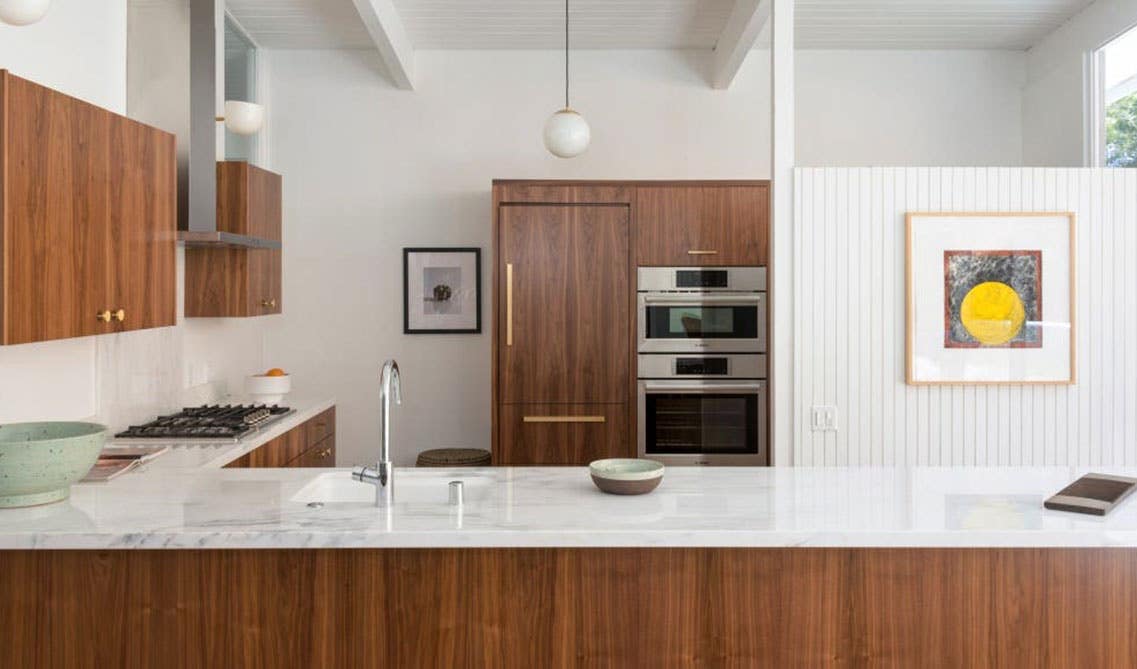 Midcentury modern kitchen design with brown cabinets and marble countertops