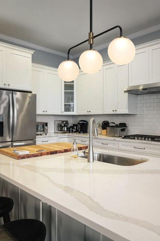 Kitchen with white cabinets, large functional island and Milky Glass Kitchen Lighting