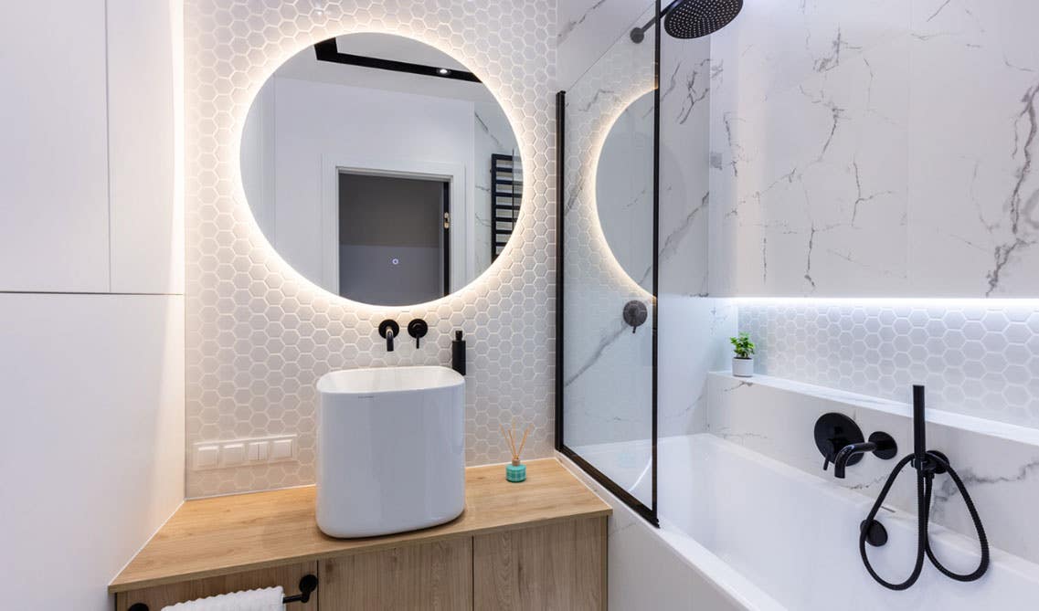 Bathroom design features wall mounted wood vanity with wood countertop, and black fitting & fixtures