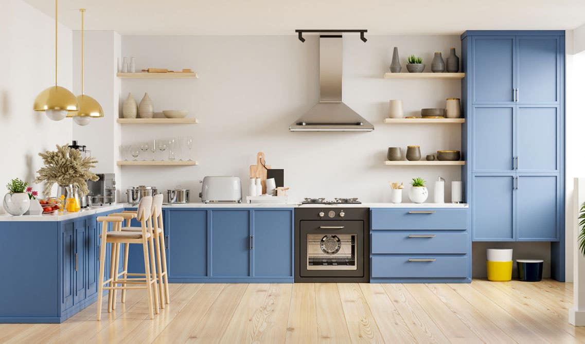 cottage-inspired kitchen feature soft blue cabinets, white countertops, open shelving with dishes, and beadboard paneling