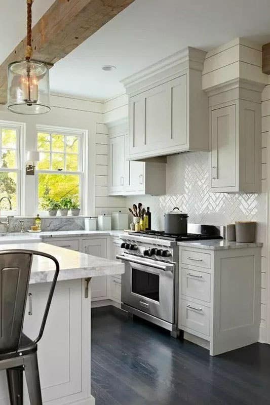 modern farmhouse kitchen with grey shaker cabinets, large island, herringbone backsplash, marble countertops