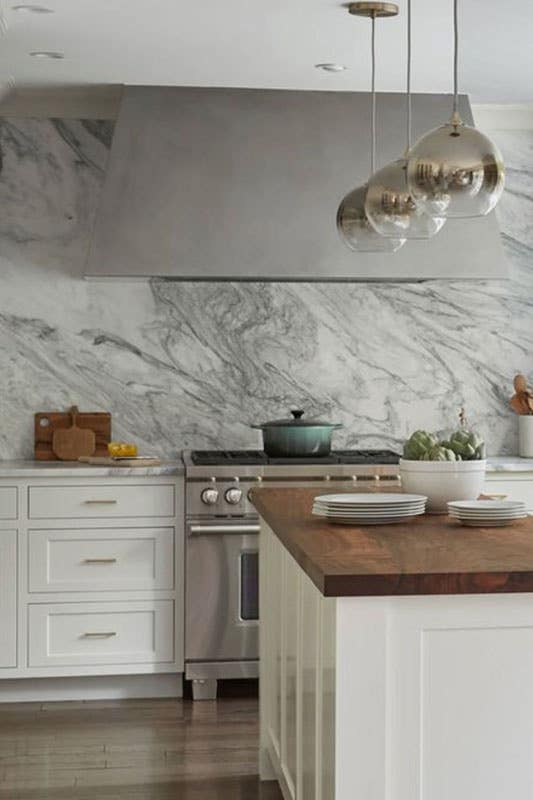 Modern kitchen with white cabinets and marble backsplash 