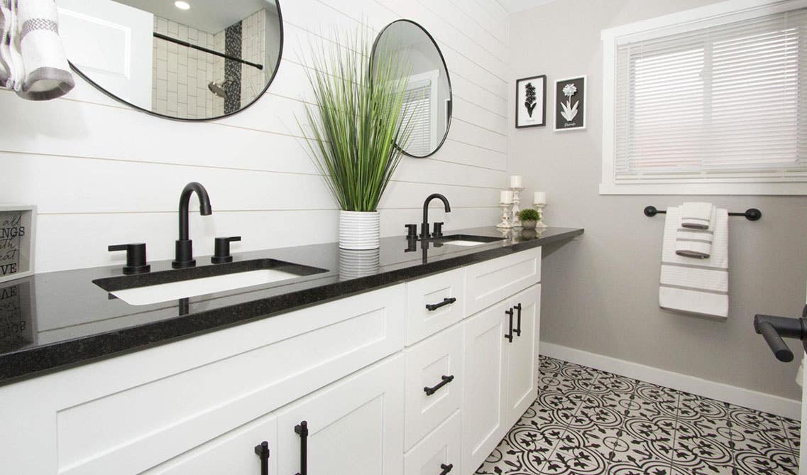 Minimalist bathroom design with white shaker vanity with black marble countertops, black matt hardwares, double sink with mirrors, pattern floor tiles 