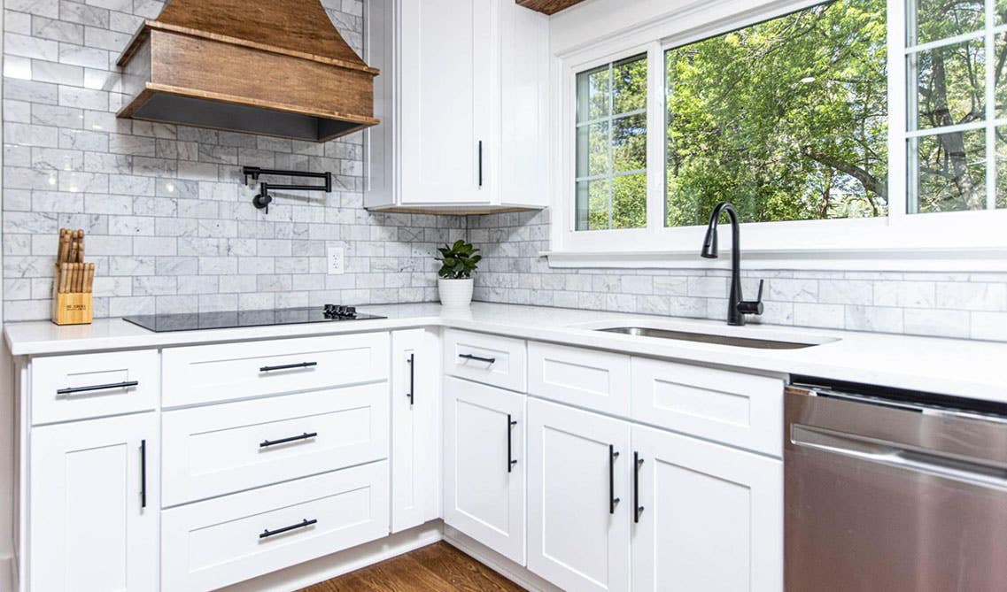 Mosaic Tiles paired with natural wood Kitchen Hood and white cabinets