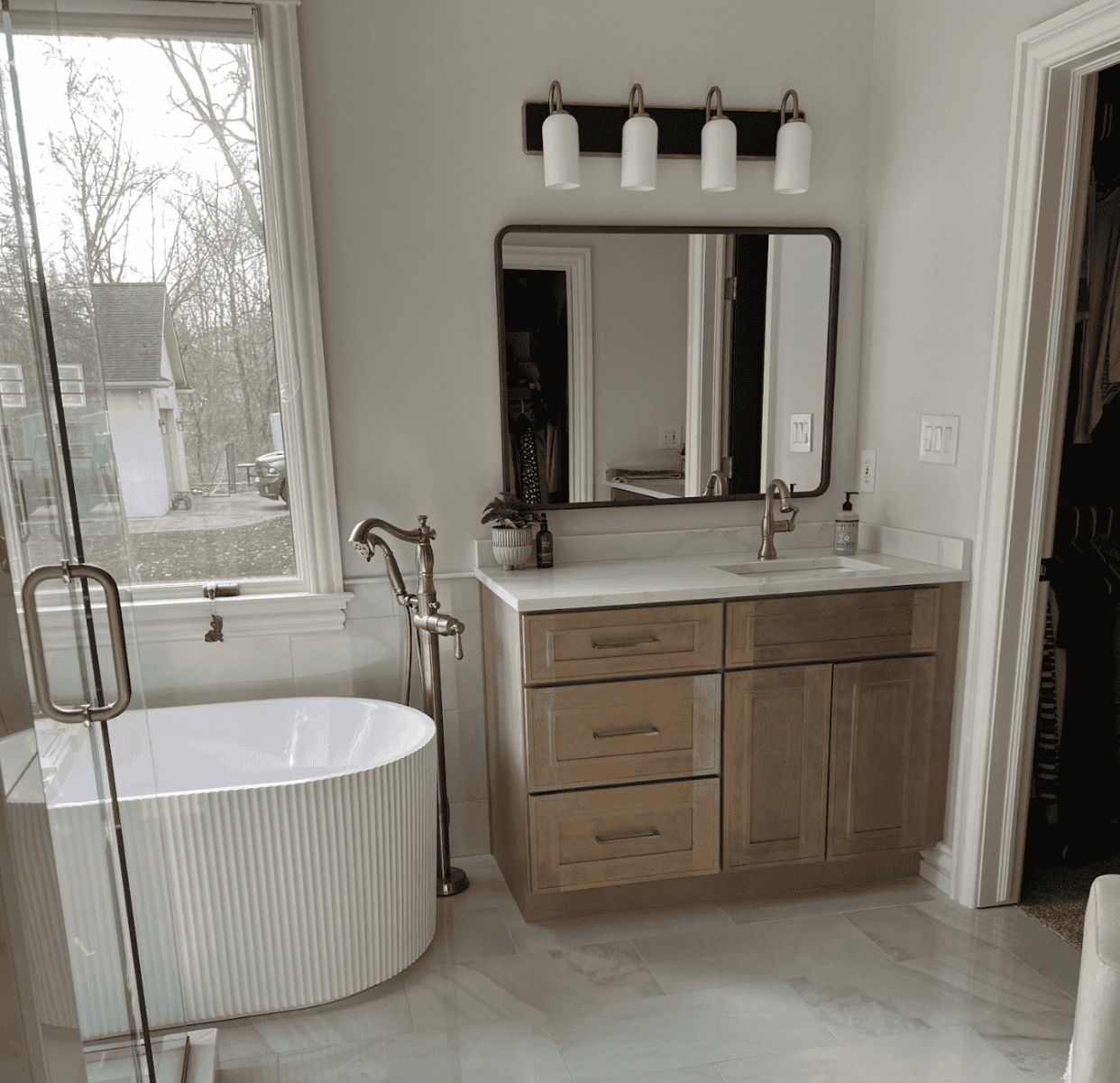 Natural shaker bathroom vanity paired with free standing bathtub and statement mirror