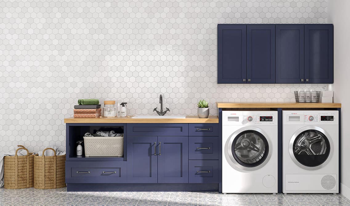 Laundry Room with two tone cabinets, washer and dryer, wood countertop and pattern backsplash