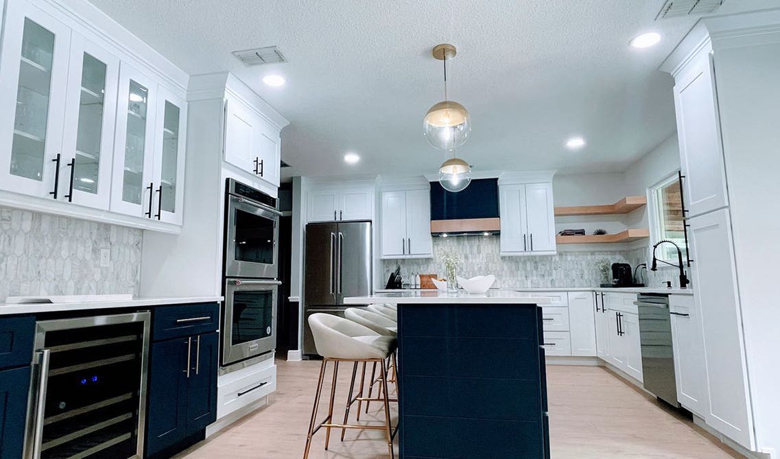 stylish two tone navy blue and white cabinets with stainless steel appliances 