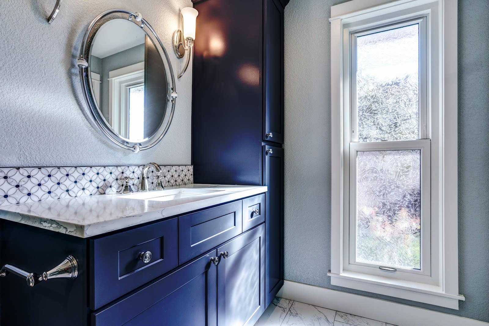 bathroom features with navy blue vanity and white countertop