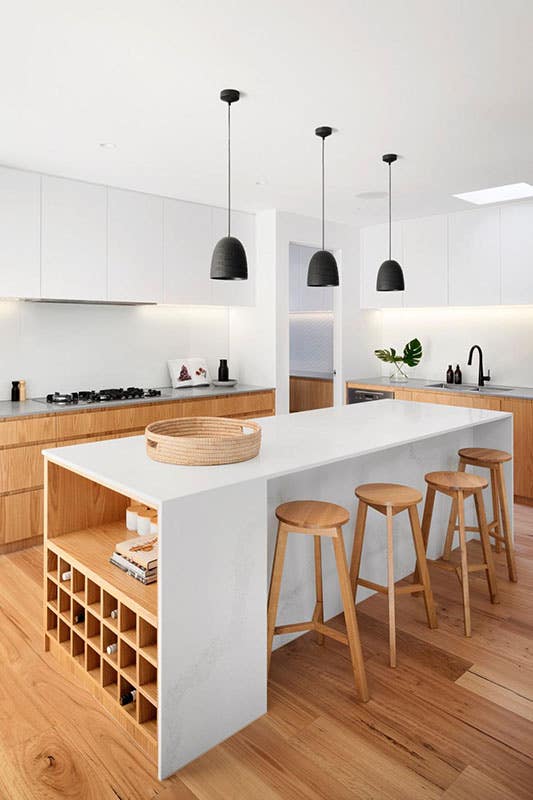 Sleek kitchen design with two toned oak cabinets and pendent light over large island, stool chairs, 