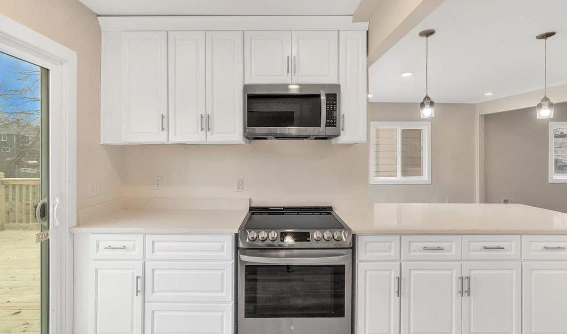 One-Wall Kitchen with white shaker cabinets with beige countertops 