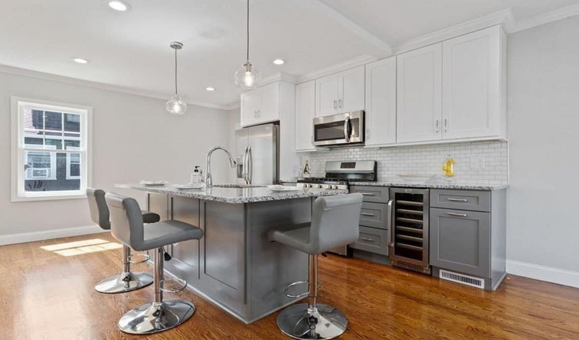 Open concept one wall kitchen design- large grey island with undermount sink, 