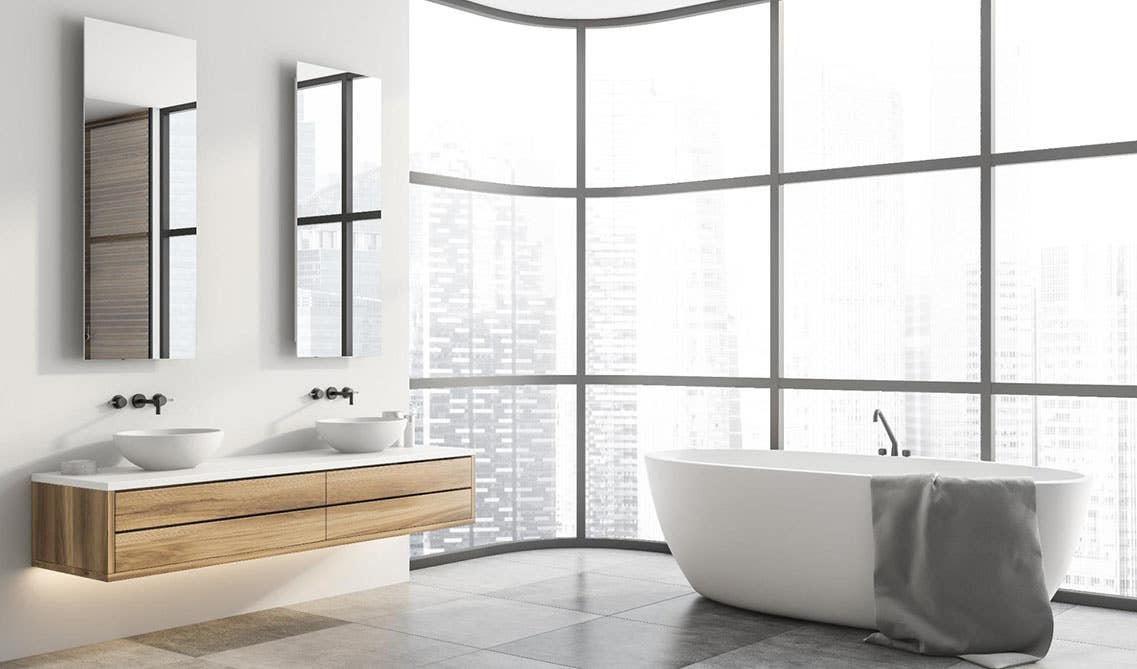 Bathroom design features wall mount vanity with with double bowl sink, and freestanding bathtub beside one large window