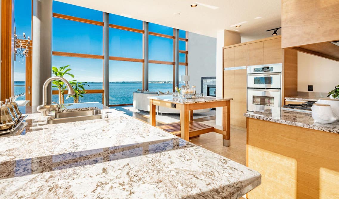 coastal kitchen design with large glass door window and natural wood cabinets