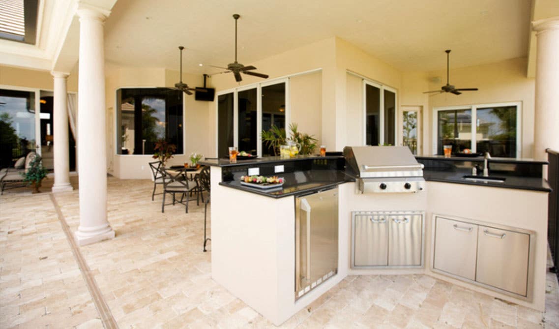 Outdoor kitchen design with table set and grill stove