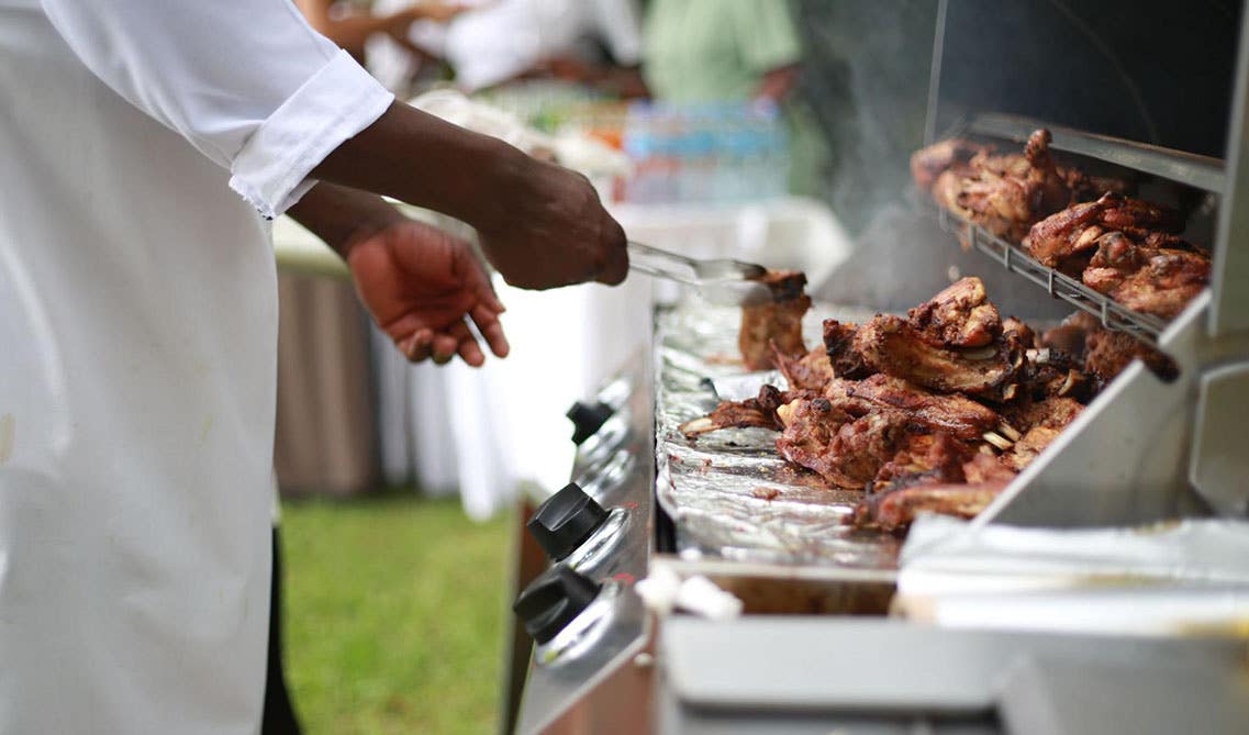 A man cooking in outdoor kitchen grill