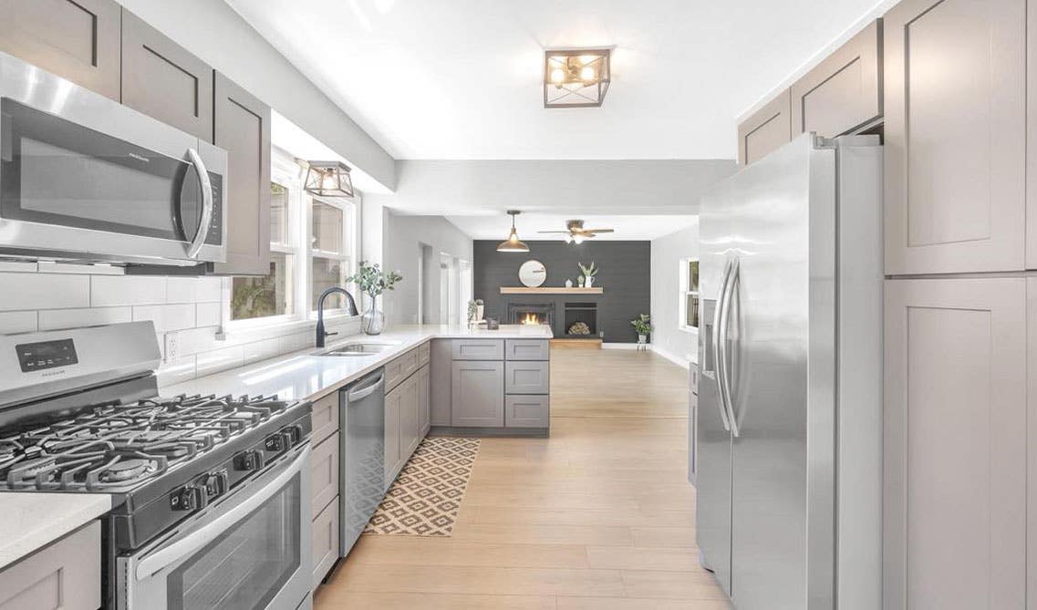 Peninsula Kitchen with gray shaker cabinets, stainless steel appliances and white countertop 