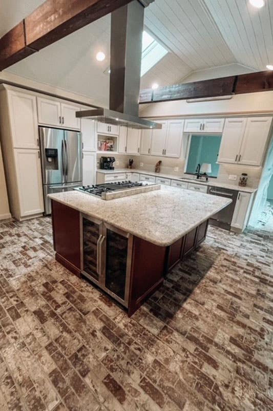 L shaped kitchen with shaker cabinets, functional island and stainless steel appliances