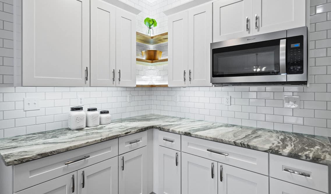 Quality white shaker cabinets with subway tile backsplash and quartz countertop