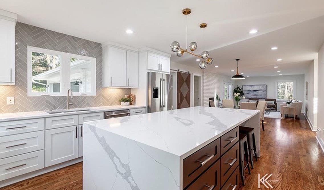 White cabinets with quartz countertops, and wooden flooring 