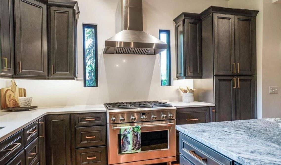 York Driftwood Grey cabinets with gold hardware and white countertops and stainless steel appliances 