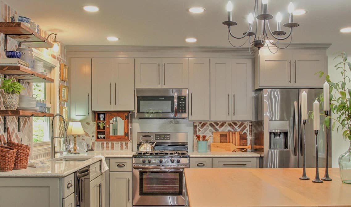 Reverse Galley Kitchen with white shaker cabinets, farmhouse sink, island, floating shelves 