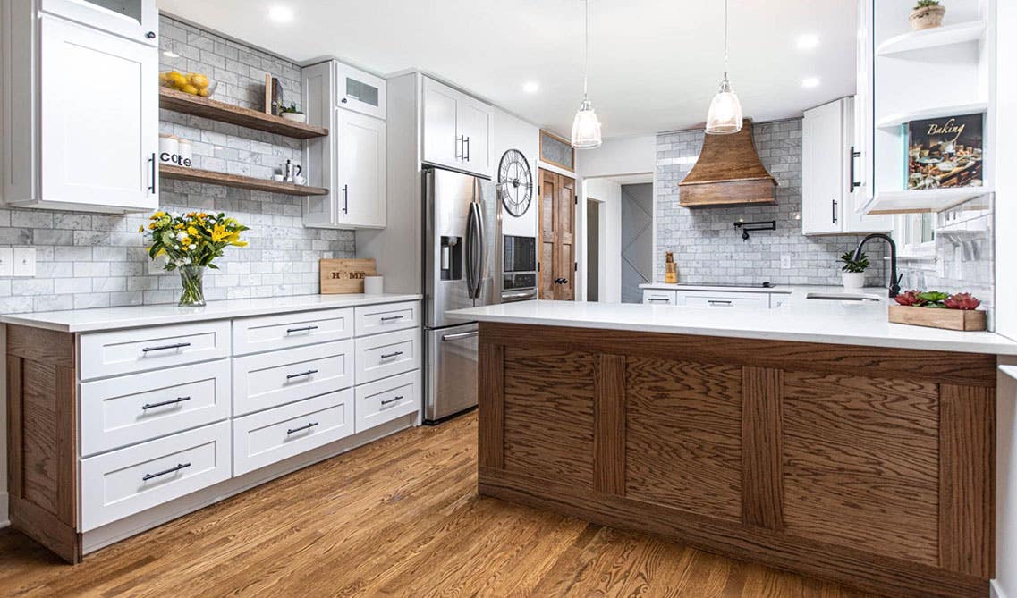 Rustic kitchen with White cabinets with natural wood island, wood hood and hardwood flooring 