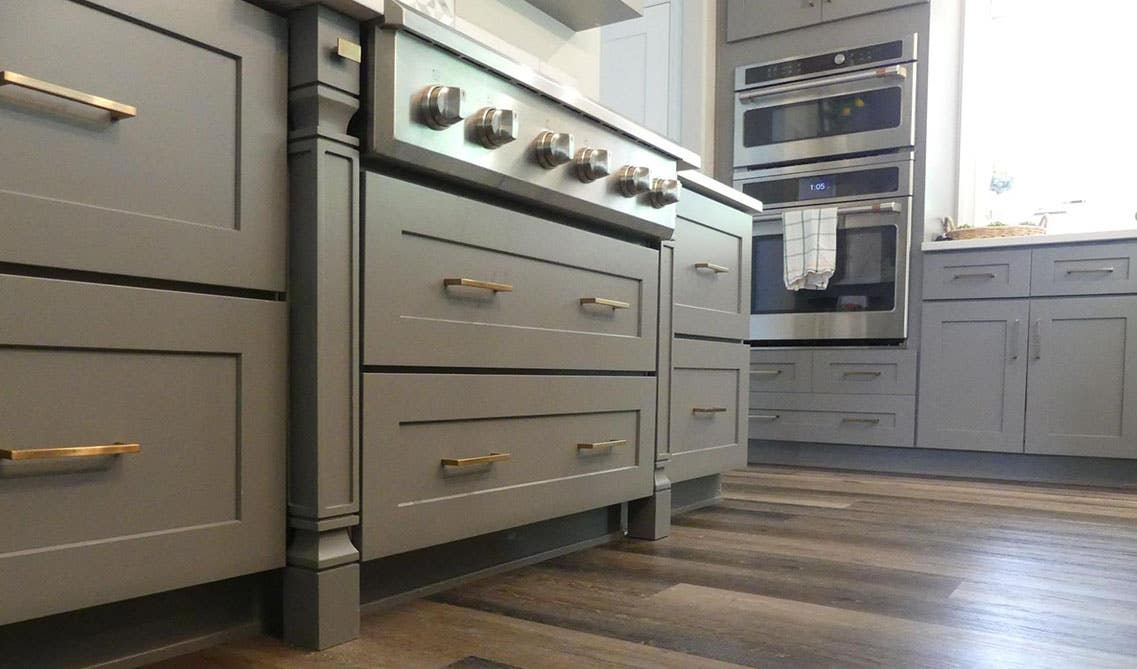 Grey cabinet with gold pulls and spc flooring 