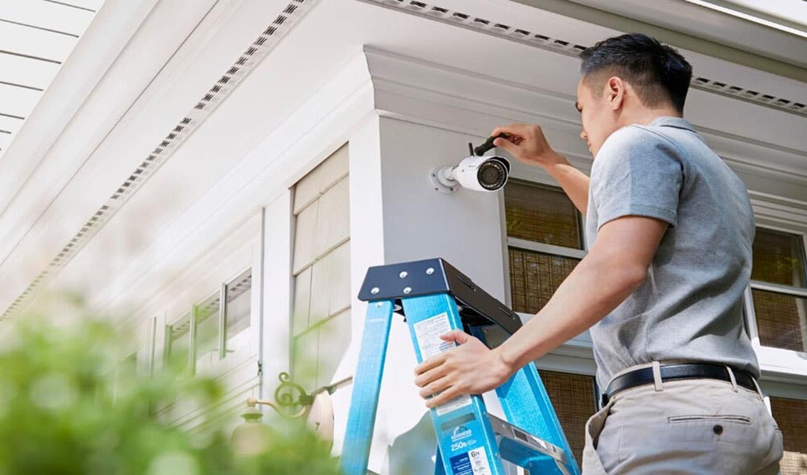 A man fixing security camera at outside of the home