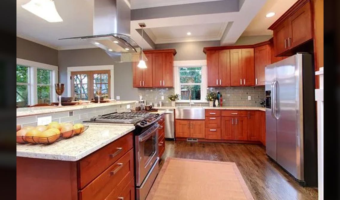 Shaker Cherry Cabinets with wooden floor and steel Appliances 