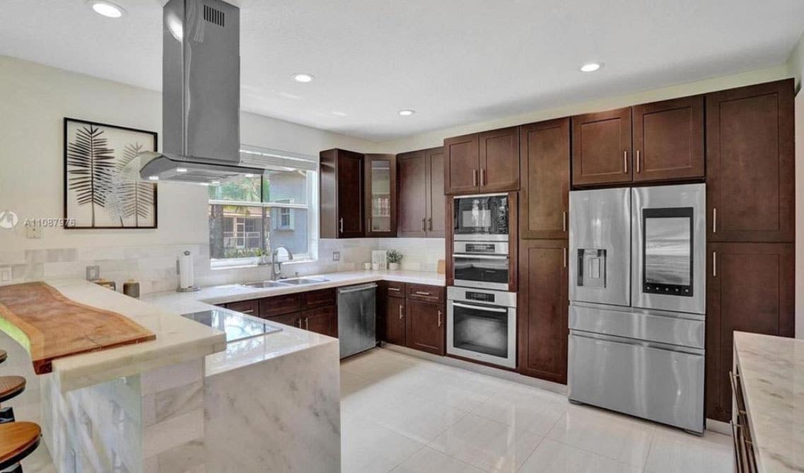 Shaker Espresso Kitchen Cabinet, Marble waterfall countertop and stainless steel appliances 