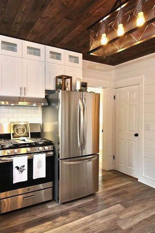 Kitchen with white cabinets, stainless steel appliances and spc flooring