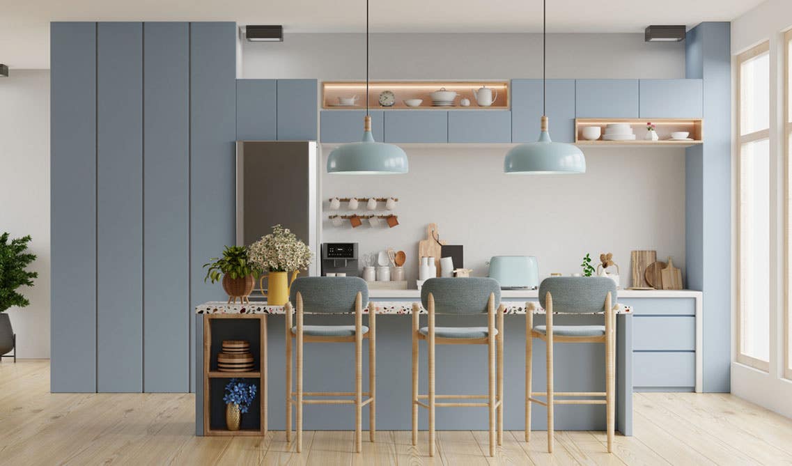 Sleek kitchen design features pale blue-gray cabinets and white quartz countertops