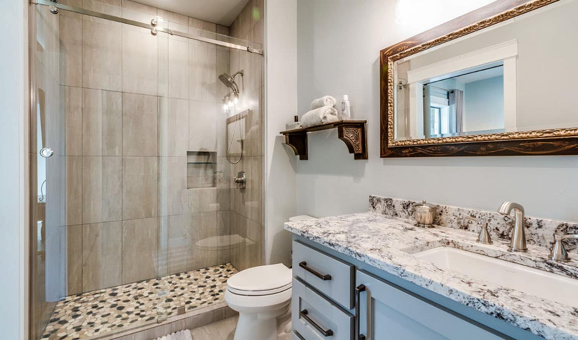 contemporary Bathroom design with sliding shower glass doors, vanity with quartz countertop and toilet sheet