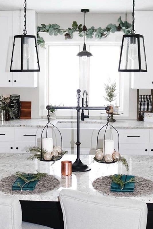 White kitchen with perfectly aligned cabinet handles and symmetrical light fixtures