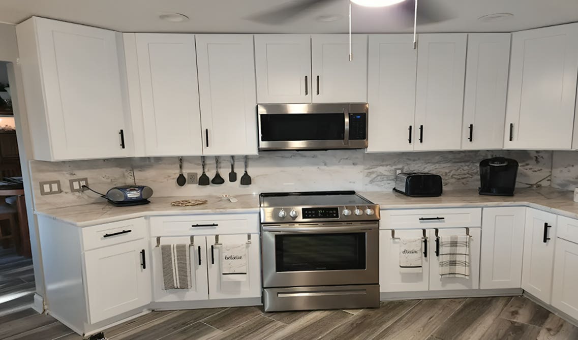 Solid Marble backsplash paired with white cabinets and stainless steel appliances 