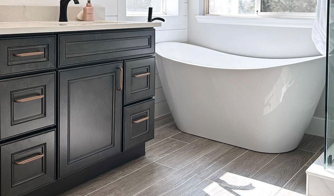 Statement Bathtub with driftwood cabinets, bronze pulls and black matt fixture 