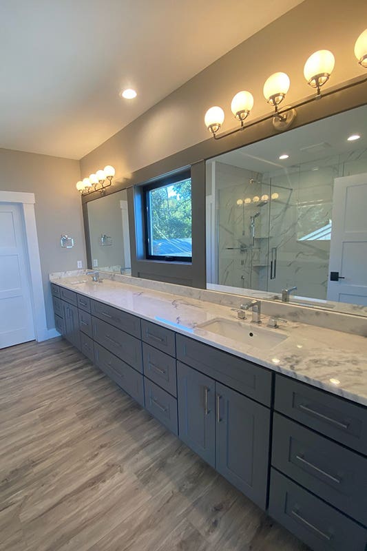 Bathroom Design with statement lighting fixtures, chic sconces and gray vanity 