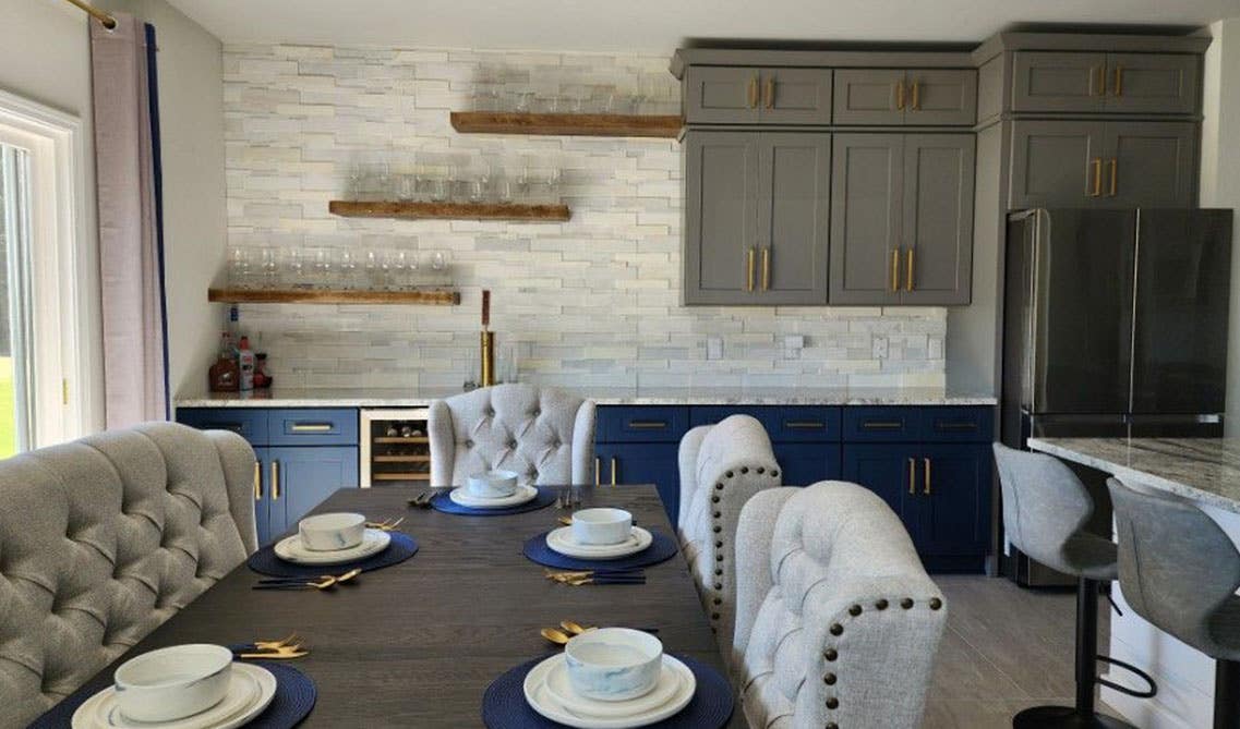 Multi-toned cabinets with Stone accent wall with wooden fixtures