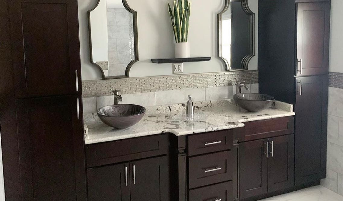 bathroom with chic and functional cabinetry, silver handles and marble countertop