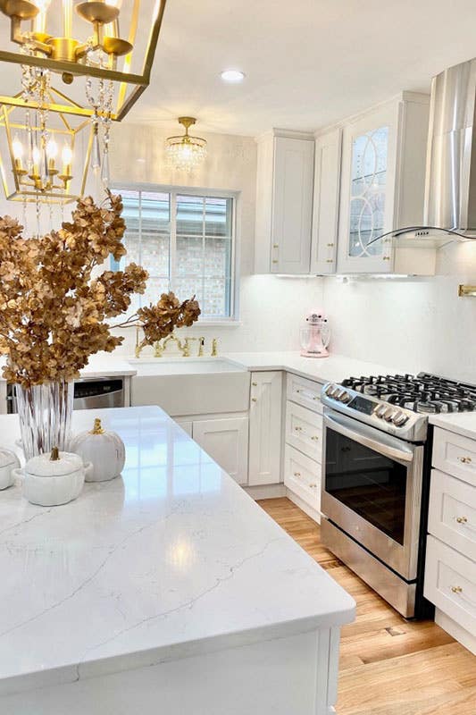 Stylish white kitchen with shaker cabinets and brass hardware 