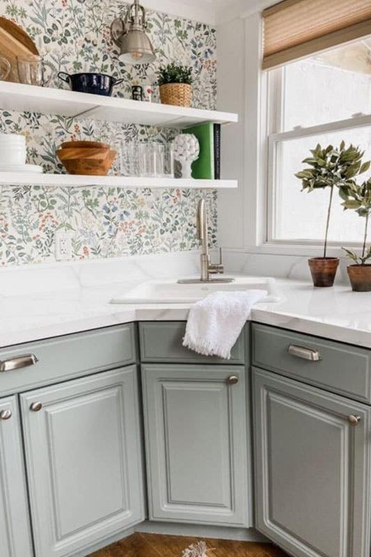 Soft pastel-colored cabinets and a vintage floral backsplash